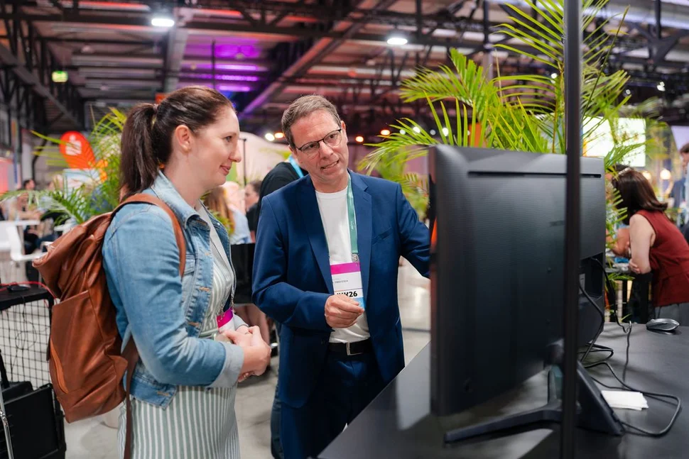 Szene mit zwei diskutierenden Teilnehmern des futureSAX-Innovationsforums vor einem Bildschirm