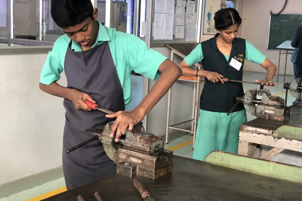 Indische Auszubildende (ein junger Mann, eine junge Frau) bei der praktischen Arbeit