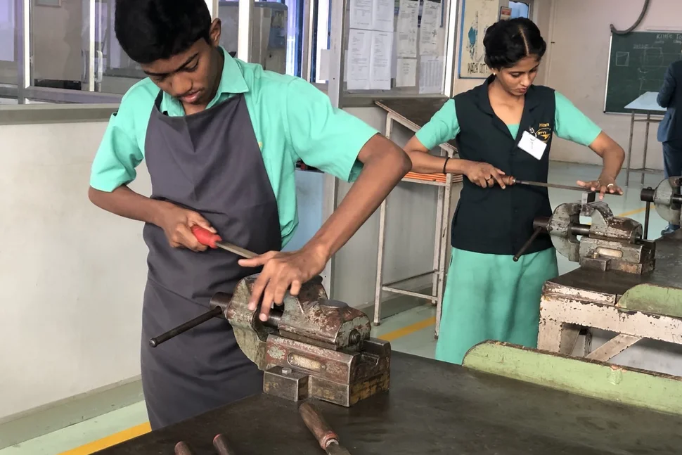 Indische Auszubildende (ein junger Mann, eine junge Frau) bei der praktischen Arbeit